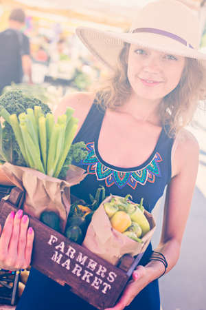 Young woman shopping at the local Farmers market.の写真素材