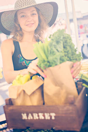 Young woman shopping at the local Farmers market.の写真素材