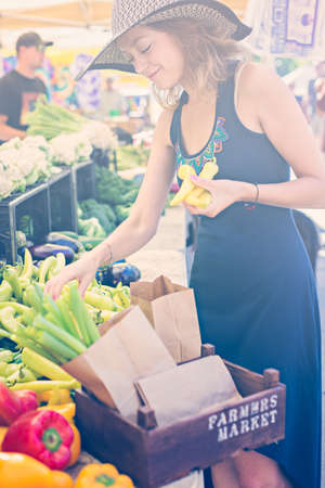 Young woman shopping at the local Farmers market.の写真素材