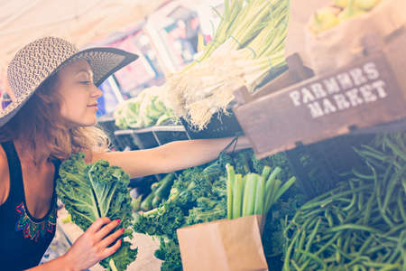 Young woman shopping at the local Farmers market.の写真素材