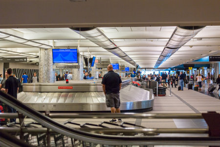 Denver, Colorado, USA-June 22, 2016.  Travelers waiting for their luggage at the baggage carousel.