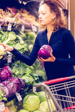 Young woman shopping in the fresh produce section at the grocery store.の写真素材