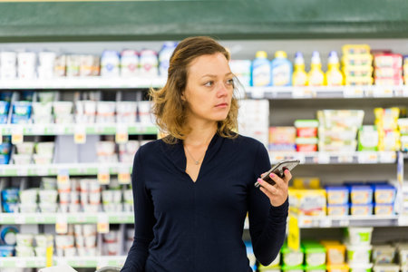 Young woman shopping in the yogurt section at the grocery store.