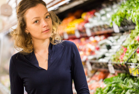 Young woman shopping in the fresh produce section at the grocery store.の写真素材