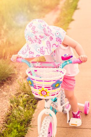 Toddler learning how to ride bicycle on the trail.の写真素材
