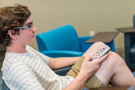 Teenager watching television in media room.