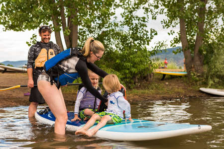 Denver, Colorado, USA-July 23, 2016. Family paddleboarding on small pond.のeditorial素材