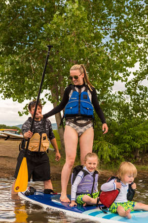 Denver, Colorado, USA-July 23, 2016. Family paddleboarding on small pond.のeditorial素材