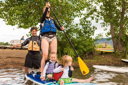 Denver, Colorado, USA-July 23, 2016. Family paddleboarding on small pond.のeditorial素材