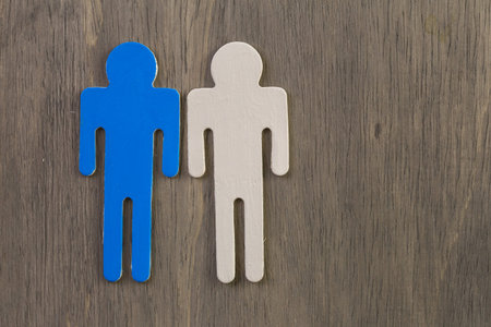 Male and female cutouts on wood background.の写真素材