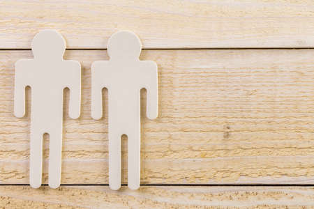 Male and female cutouts on wood background.の写真素材