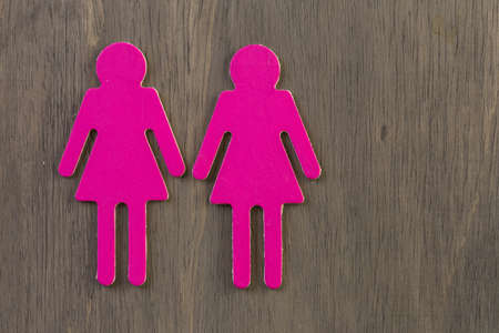 Male and female cutouts on wood background.の写真素材