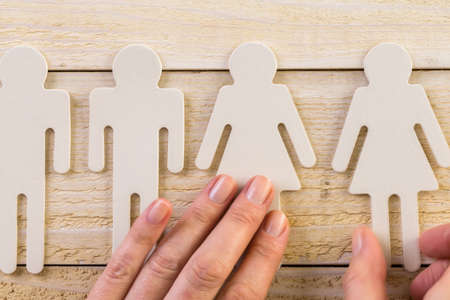 Male and female cutouts on wood background.の写真素材