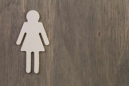 Male and female cutouts on wood background.の写真素材