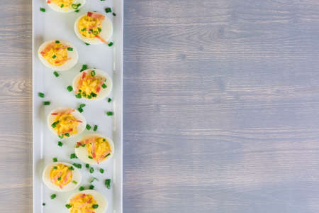 Deviled eggs garnished with green onions and bacon.の写真素材