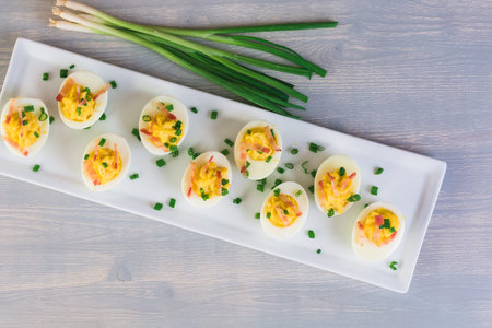 Deviled eggs garnished with green onions and bacon.の写真素材