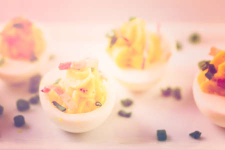 Deviled eggs garnished with green onions and bacon.の写真素材