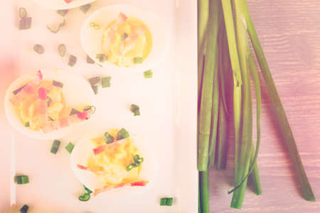 Deviled eggs garnished with green onions and bacon.の写真素材