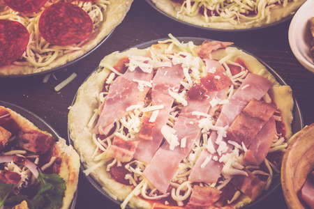 Preparing individual pizzas from pizza bar.の写真素材