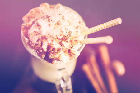 Traditional holiday drink egg nog garnished with whipped cream in the glass.の写真素材