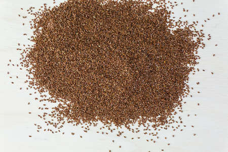 Flax seeds on painted wood board.の写真素材