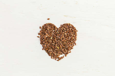 Flax seeds on painted wood board.の写真素材