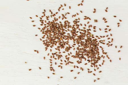 Flax seeds on painted wood board.の写真素材