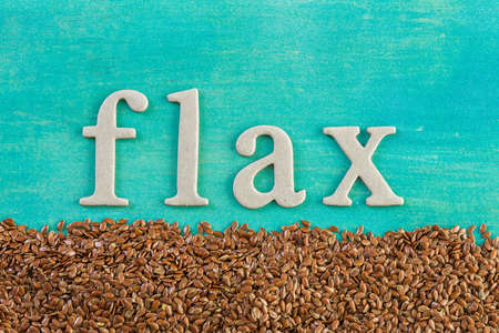 Flax seeds on painted wood board.の写真素材