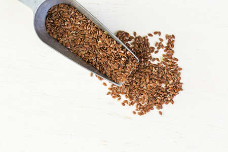 Flax seeds on painted wood board.の写真素材