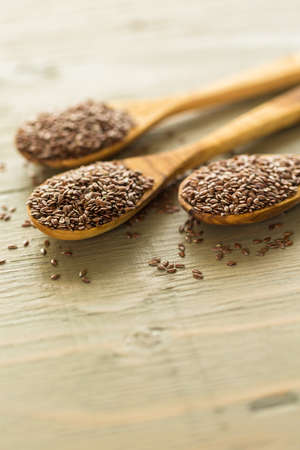 Flax seeds on painted wood board.の写真素材