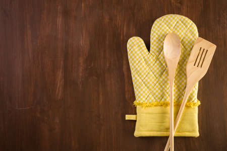 Yellow oven mitt on wood background.の写真素材