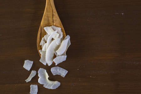 Dehydrated coconut flakes on wooden spoon.の写真素材