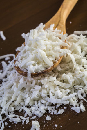 Dehydrated coconut flakes on a wood background.の写真素材