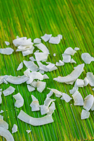 Dehydrated coconut flakes on a green background.の写真素材