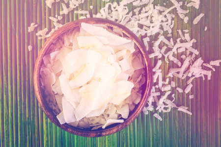 Dehydrated coconut flakes in wooden bowl.の写真素材
