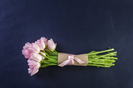 Bouquet of pink tulips on a black background.