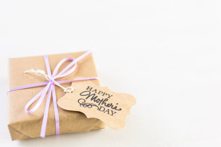 Small gift for Mother's Day on a white wood board.