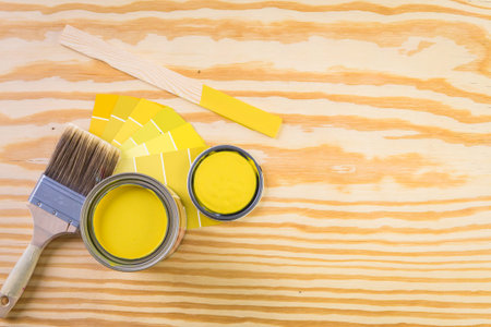 Paint in metal paint can and painters tools on a wood board.の写真素材
