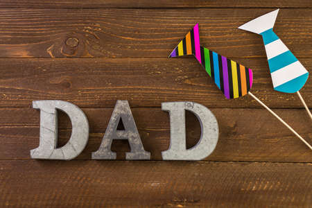 Metal letters DAD on a painted wood background.の写真素材