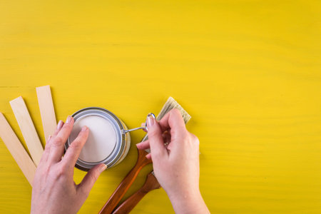 Paint in metal paint can and painters tools on a wood board.