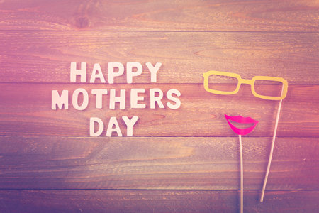 Unfinished wood lettrs sign Happy Mother's Day on a painted wood background.の写真素材