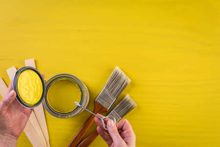 Paint in metal paint can and painters tools on a wood board.の写真素材