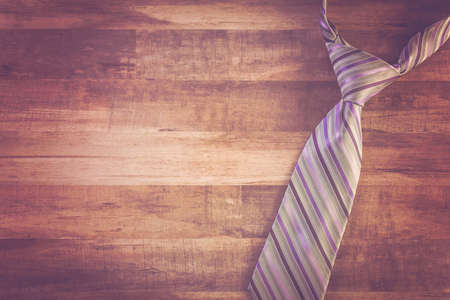 Striped men's tie on a wood background.の写真素材