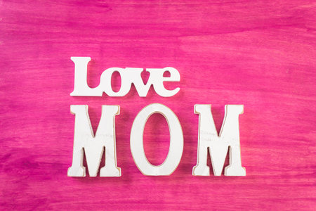 White letters MOM on a painted wood background.の写真素材