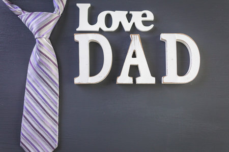 White letters DAD on a painted wood background.