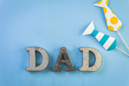 Metal letters DAD on a painted wood background.の写真素材
