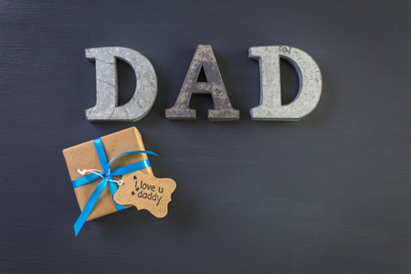Metal letters DAD on a painted wood background.の写真素材