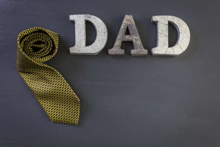 Metal letters DAD on a painted wood background.の写真素材