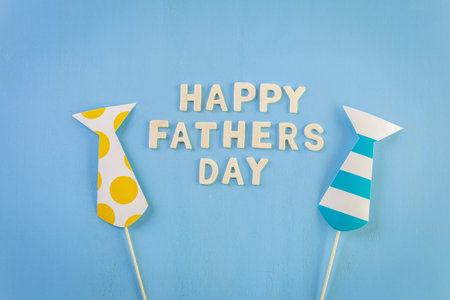 Unfinished wood lettrs sign Happy Father's Day on a painted wood background.の写真素材