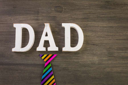 White letters DAD on a painted wood background.の写真素材
